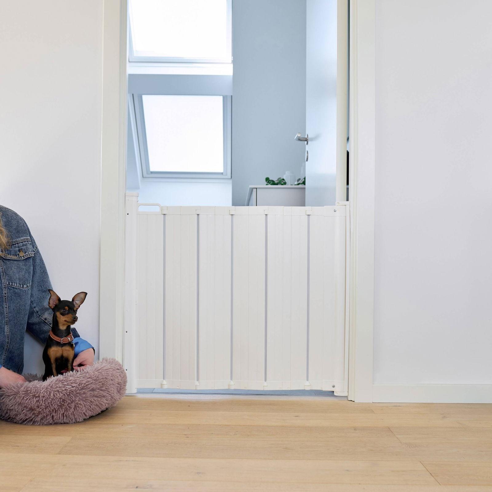 Vit dragspelsgrind från DogSpace utfälld i en dörröppning