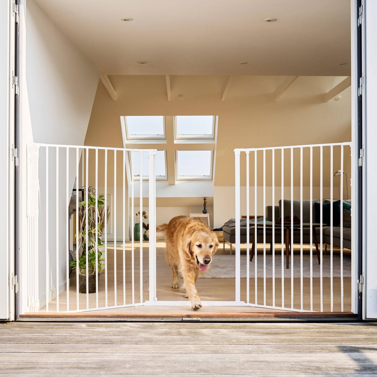 Vit utdragbar hundgrind från DogSpace monterad i en bred öppning
